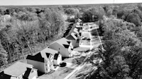 a black and white photo of a row of houses in a wooded area